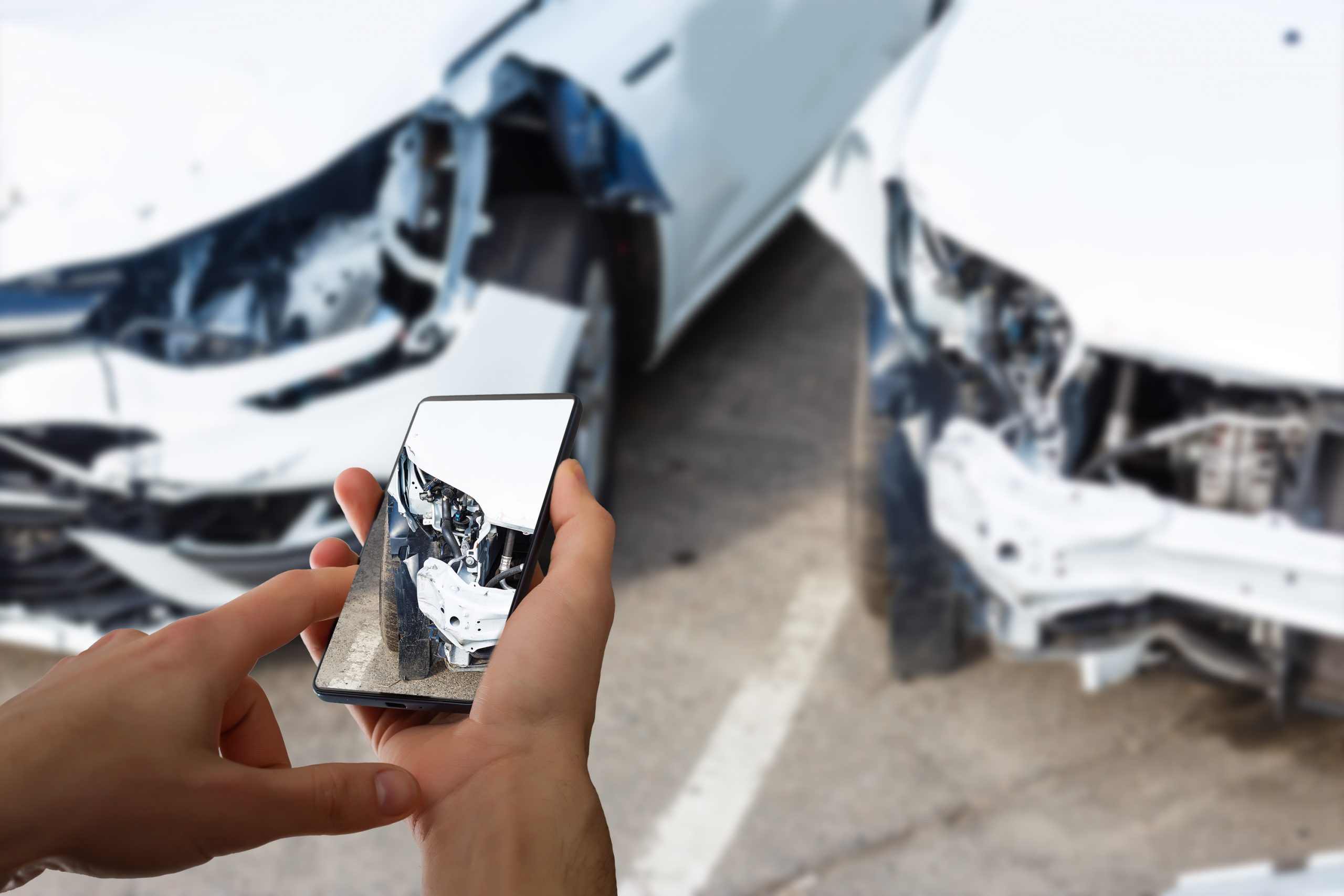 Mann dokumentiert Unfallschaden am Fahrzeug mit dem Smartphone